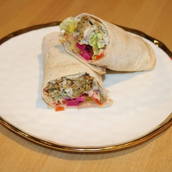 Two Wahib's Mediterranean Express shawarma wraps, filled with meat, lettuce, and pickled vegetables.